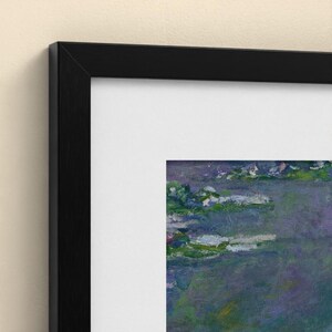 Puede incluir: Una pieza de arte mural enmarcada que presenta una pintura impresionista de un estanque con nen&uacute;fares. La obra muestra tonos azules, morados y verdes, encerrada en un marco negro fino con un borde de paspart&uacute; blanco alrededor de la impresi&oacute;n.