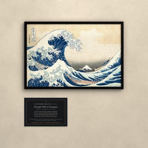 May include: A framed print of The Great Wave off Kanagawa featuring a large blue wave, white foam, and Mount Fuji in the background. Below the print is a black rectangular information card with white text detailing the artwork's history.