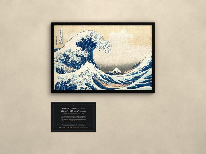 May include: A framed print of The Great Wave off Kanagawa featuring a large blue wave, white foam, and Mount Fuji in the background. Below the print is a black rectangular information card with white text detailing the artwork's history.