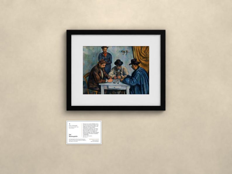 May include: A framed art print of Paul C&eacute;zanne's The Card Players, featuring four figures seated around a table. The painting is enclosed in a black frame with a white mat. Below the frame is a small white informational card with text.