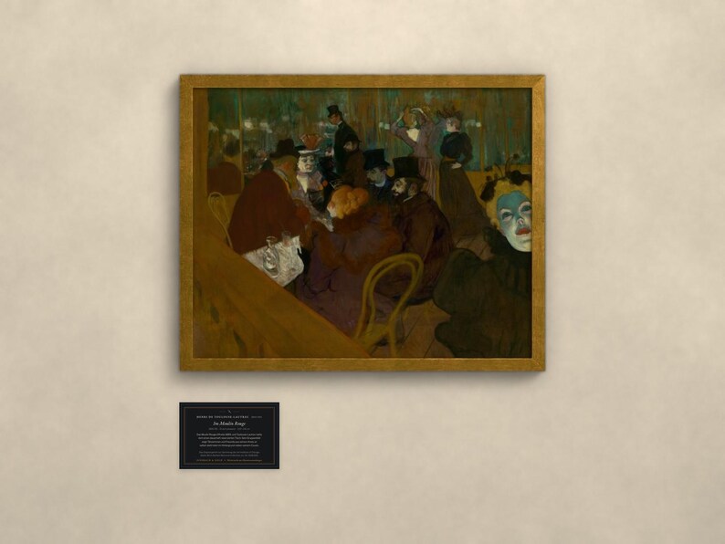 May include: A framed print of the painting At the Moulin Rouge by Henri de Toulouse-Lautrec, featuring a group of people in a dimly lit interior, with a small black informational plaque mounted below the artwork on the wall.