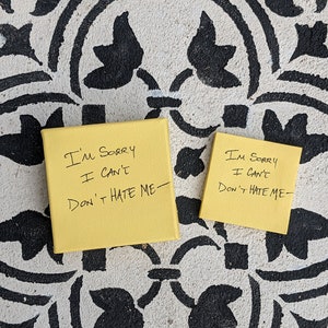 May include: Two yellow sticky notes with black handwritten text. The text on both notes reads "I'm sorry I can't Don't hate me".