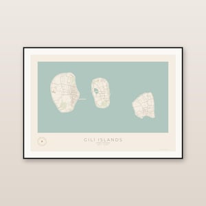 May include: A framed wall art print featuring a map of the Gili Islands in Indonesia. The design displays three islands in cream against a muted sage green background, with the text GILI ISLANDS LOMBOK, INDONESIA printed at the bottom.