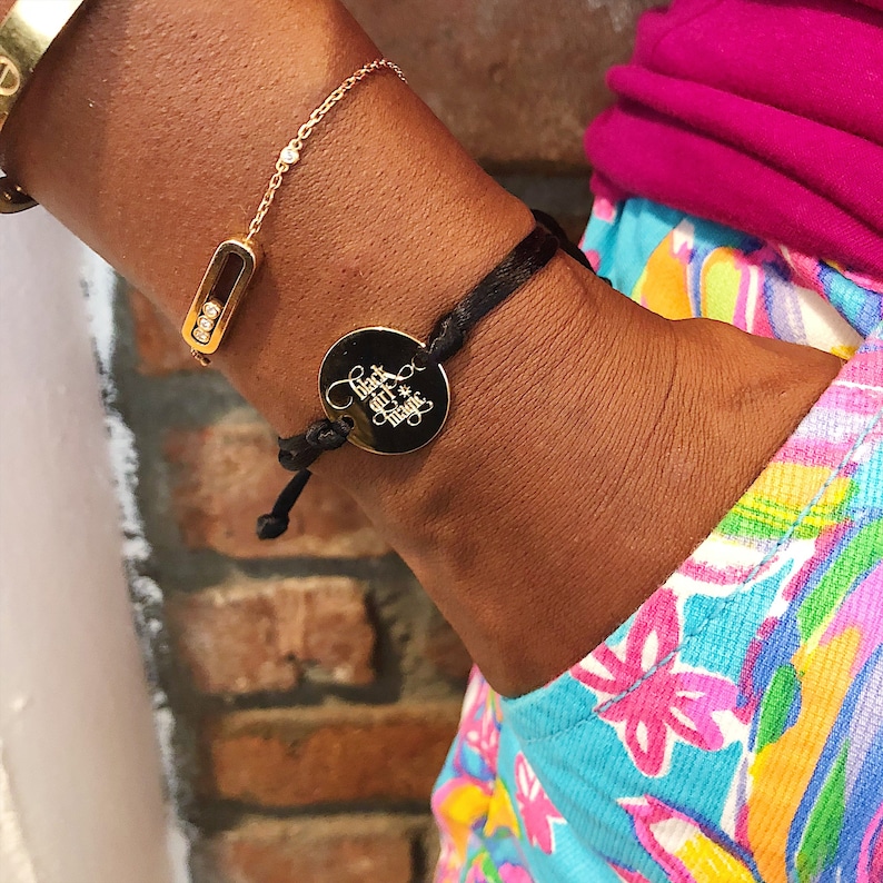 May include: A black bracelet with a gold charm that says "Black girl magic".