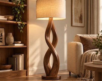 May include: A floor lamp featuring a dark brown wooden base with a twisted, sculptural design and a cylindrical, light-colored fabric lampshade. The lamp emits a warm, soft glow, illuminating the surrounding area with a gentle light.