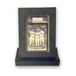 May include: A graded Topps Now baseball card featuring three Los Angeles Dodgers players in white uniforms. The card is encased in a clear plastic slab with a CSG 10 Gem Mint label, mounted in a black rectangular display frame.