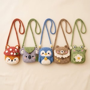 Könnte beinhalten: Fünf gehäkelte Umhängetaschen mit Tiermotiven: ein Fuchs mit Pilzhut, ein Koala mit Blatt, ein blauer Pinguin mit Stern, ein brauner Bär mit Spitzenkragen und ein grüner Frosch mit einer weißen Blume, alle mit langen Trageriemen.