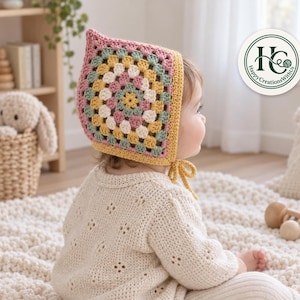 May include: A crochet bonnet featuring a spiral granny square pattern in shades of dusty pink, mustard yellow, sage green, and cream. The bonnet has a mustard yellow border and matching chin ties. A circular logo reads Happy Creations With Us.