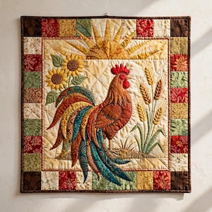 May include: A square fabric wall hanging featuring a central applique of a rooster with multi-colored patterned feathers, standing beside stalks of wheat and sunflowers under a yellow sun, framed by a border of small patchwork squares.