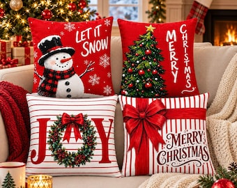 May include: A set of four square throw pillows featuring Christmas themes. Two pillows are red with white text reading Let It Snow and Merry Christmas, featuring a snowman and a tree. Two pillows have white and red stripes with a wreath and a bow.