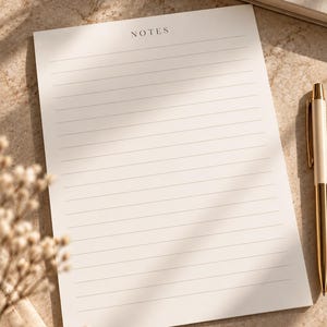 May include: A rectangular off-white notepad featuring the word NOTES printed in a simple black serif font at the top, followed by a series of thin, evenly spaced horizontal lines for writing across the entire page surface.