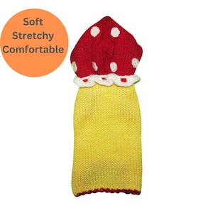 May include: Yellow knitted dog sweater with a red mushroom-shaped hood with white polka dots.