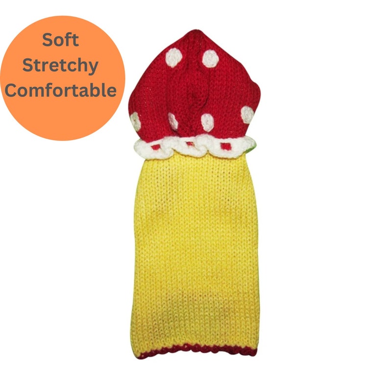 May include: Yellow knitted dog sweater with a red mushroom-shaped hood with white polka dots.