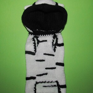Peut inclure: Pull-over &agrave; capuche en tricot blanc et noir pour un petit chien ou un chat. Le pull a un motif ray&eacute; et une capuche noire.
