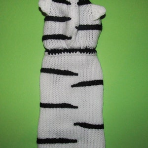 Peut inclure: Pull-over en tricot blanc pour chien avec des rayures noires et une capuche. La capuche a deux petites oreilles.