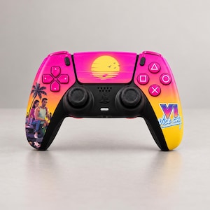 Op de afbeelding: Een draadloze videogamecontroller met een levendig roze en geel kleurverloop. Het centrale touchpad toont een gele zonsondergang boven water, terwijl aan de rechterkant de tekst VI Vice City in blauwe en witte letters staat.