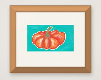 Puede incluir: Una obra de arte enmarcada que presenta una calabaza naranja brillante con un tallo verde, centrada sobre un fondo turquesa sólido. La ilustración está encerrada en un marco de madera marrón claro con un borde blanco.