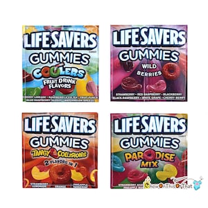 Op de afbeelding: Vier verpakkingen Life Savers Gummies snoep. De verpakkingen bevatten verschillende smaken: Coolers, Wild Berries, Tangy Collisions en Paradise Mix. Elke verpakking toont de smaaknaam en een ingrediëntenlijst.