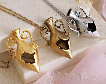 May include: Three gold, silver, and antique gold necklaces with a detailed, ornate, open-work,  pendant in the shape of a small, pointed vase.