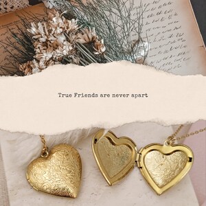 May include: Two gold heart-shaped lockets with intricate designs. The lockets are open and the inscription "True Friends are never apart" is visible on a beige background.