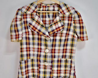 May include: A red, yellow, and blue plaid short-sleeved button-up shirt with a collar and a pocket.
