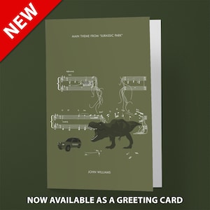 May include: A green greeting card with a white illustration of a Tyrannosaurus Rex dinosaur roaring over a musical score. The text "MAIN THEME FROM "JURASSIC PARK" and "JOHN WILLIAMS" are printed on the card.