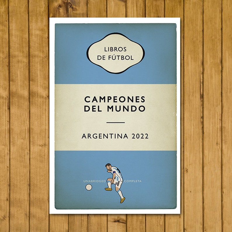 May include: A vintage-style book cover with a blue background and white text. The title is "Campeones del Mundo" with the subtitle "Argentina 2022". The cover also features a cartoon illustration of a soccer player kicking a ball.