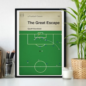 May include: Framed print titled "The Great Escape" featuring a football field diagram. The artwork includes text: "a Football Classic" and "'05", with the author's name, Geoff Horsfield. The background is a light beige color.