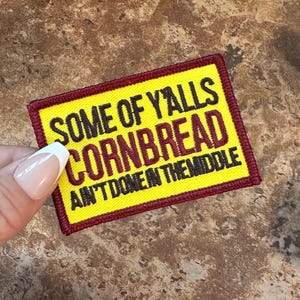 May include: Yellow and maroon embroidered patch with the text "Some of Y'alls Cornbread Ain't Done in the Middle."