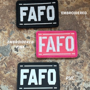 May include: Three embroidered patches with the text "FAFO" in white lettering. The top patch is black with white stitching, the middle patch is pink with white stitching, and the bottom patch is black with white stitching. The top patch is labeled "Embroidered", the middle patch is labeled "Embroidered Pink", and the bottom patch is labeled "PVC".