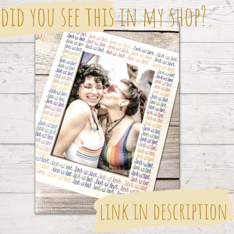 May include: A framed photograph featuring two smiling people, one kissing the other on the cheek. The frame is decorated with the words "love is love" in a rainbow pattern. The image is on a wooden background, with the text "DID YOU SEE THIS IN MY SHOP?" and "LINK IN DESCRIPTION".