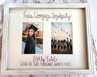 Op de afbeelding: Een witte, verweerde houten fotolijst met twee afstudeerfoto's. De passe-partout bevat de tekst Texas Woman's University, de naam Holly Eitel en de tekst Class of Two Thousand Twenty-Five in donkerbruine letters in een cursief handschrift.