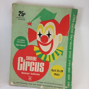 May include: A vintage 25 cent program for the Shrine Circus, held at the Municipal Auditorium from April 23-29, 1965. The program features a colorful illustration of a clown with a red nose and yellow hair. The text "Yaarab Temple 23rd Annual" is also visible.