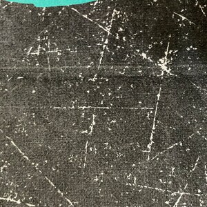 Peut inclure: Gros plan sur une surface en tissu noir avec des rayures et des marques blanches. Le tissu a un tissage textur&eacute;.