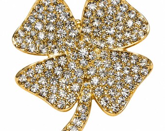Spilla a forma di quadrifoglio in cristallo dorato, in lega placcata oro e con strass trasparenti.