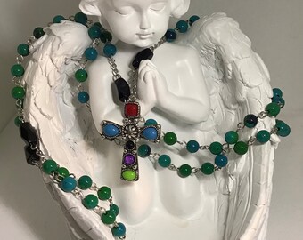 Hermoso rosario de cuentas de vidrio en color verde azulado oscuro y negro con una hermosa cruz engastada con cabujón