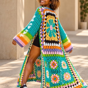 May include: A long, open-front crochet cardigan featuring a vibrant patchwork of granny squares in teal, yellow, orange, pink, purple, and black. The garment has wide, long sleeves and a floor-length hem, showcasing a colorful floral motif.
