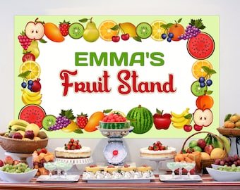 May include: A fruit stand party table setting with a banner that says "Emma's Fruit Stand". The table is decorated with fruit-themed desserts, fruit bowls, and a scale.