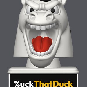 May include: A white horse head figurine with a black mane, wide open mouth, and a bright red tongue. The base is a rectangular white block featuring a black plaque with the white and yellow text %uckThatDuck printed in a bold sans-serif font.