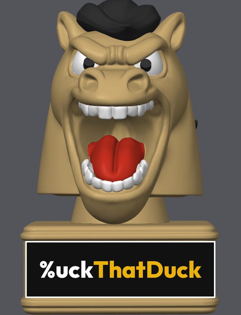May include: A tan-colored horse head figurine with a black mane, white teeth, and a red tongue, featuring an aggressive expression. The base is a rectangular tan block with a black plaque displaying the white and yellow text %uckThatDuck.
