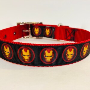 Pu&ograve; includere: Collare per cani rosso e nero con un motivo ripetuto del viso di Iron Man.