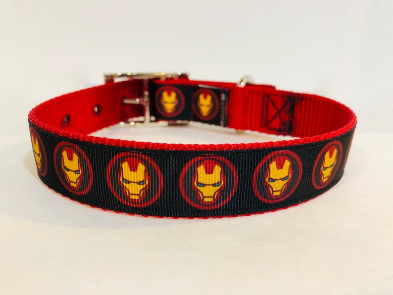Pu&ograve; includere: Collare per cani rosso e nero con un motivo ripetuto del viso di Iron Man.