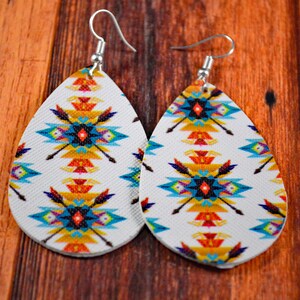 May include: A pair of teardrop-shaped earrings with a white background and a colorful geometric pattern. The pattern features blue, yellow, red, and black colors.