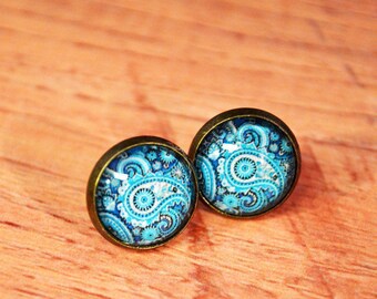 May include: A pair of blue and white paisley patterned earrings with bronze settings.