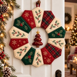 May include: A quilted fabric Christmas wreath featuring alternating segments of red, dark green, and cream fabric. The segments are decorated with embroidered holly, berries, and snowflakes, with a central hanging red fabric Christmas tree.