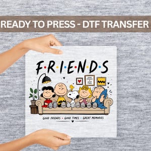 May include: A DTF transfer featuring the Peanuts characters sitting on a couch with the text "FRIENDS" above and "GOOD FRIENDS GOOD TIMES GREAT MEMORIES" below. The design includes a lamp, a plant, and framed wall art on a light gray background.