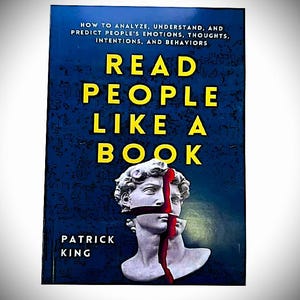 May include: A book titled Read People Like A Book by Patrick King. The cover is dark blue with yellow text and features a white classical bust sculpture split by a vertical red line that runs through the center of the face.