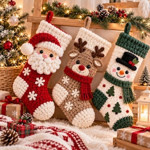 Puede incluir: Tres calcetines navideños de ganchillo hechos a mano con personajes festivos: un Santa Claus rojo, un reno beige con bufanda roja y un muñeco de nieve blanco con bufanda y sombrero de copa verdes, decorados con copos de nieve.