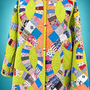 Puede incluir: Una chaqueta acolchada de manga larga con una base de color verde lima vibrante y un diseño de patchwork de tiras de tela multicolores dispuestas en patrones circulares entrelazados. La chaqueta tiene cuello redondo y tres botones de presión metálicos plateados.