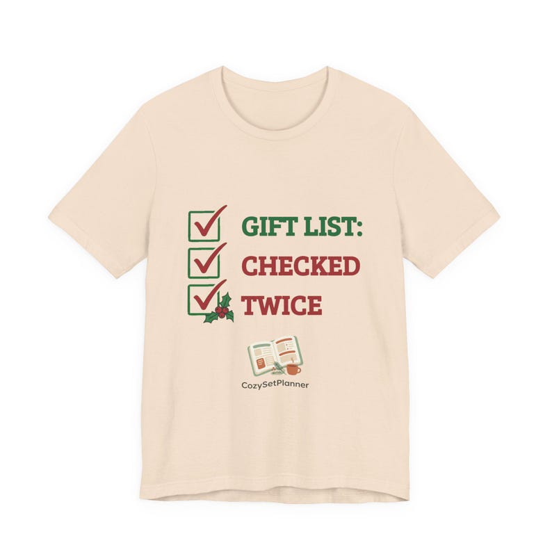 A second cream mockup angle of the short-sleeve checked it twice Christmas t-shirt with the three-checkbox "GIFT LIST: CHECKED TWICE" design and a small open planner illustration.